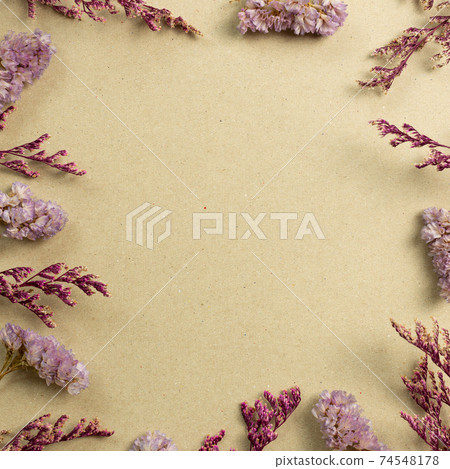 Pink statice and misty blue dry flowers on brown kraft paper background. flat lay, top view, copy space 74548178