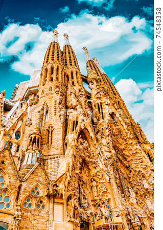 BARCELONA, SPAIN - SEPT 02, 2014: The Basilica of La Sagrada Familia against blue sky.Most amazing and fabulous creations of the great architect by Antoni Gaudi, its construction began in 1882 and BARCELONA, SPAIN - SEPT 02, 2014: The Basilica of La Sagrada Familia against blue sky.Most amazing and fabulous creations of the great architect by Antoni Gaudi, its construction began in 1882 and 74548358