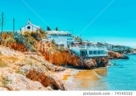 View of the beach and the sea shore of a small resort town Sitge View of the beach and the sea shore of a small resort town Sitge 74548382