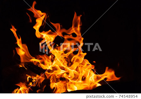 Arson or natural disaster. Burning tree branches. Remains from fire, hot red-orange coals from burnt wood. Arson or natural disaster. Burning tree branches. Remains from fire, hot red-orange coals from burnt wood. 74548954