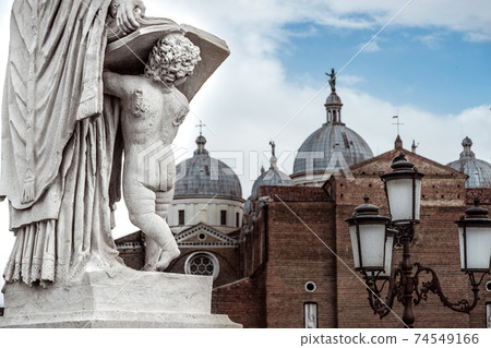 statue holding book on prato della valle in front of saint Guistina Basilica statue holding book on prato della valle in front of saint Guistina Basilica 74549166