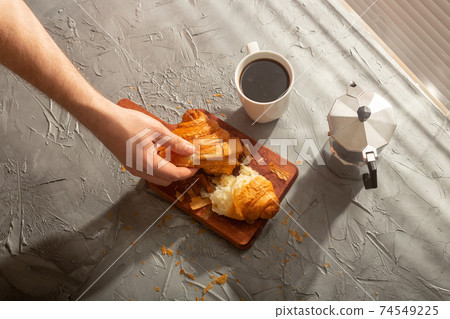 Breakfast with croissant on cutting board and black coffee. Morning meal and breakfast concept. Breakfast with croissant on cutting board and black coffee. Morning meal and breakfast concept. 74549225