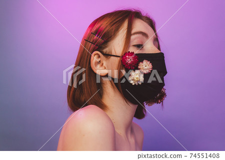 Girl in protective antiviral mask with flowers 74551408