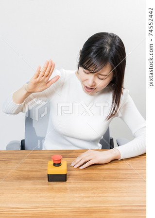 Woman trying to press the switch Woman trying to press the switch 74552442