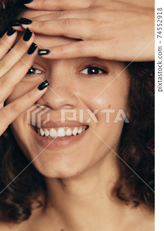 Girl hiding her face behind her hands while posing to camera 74552918