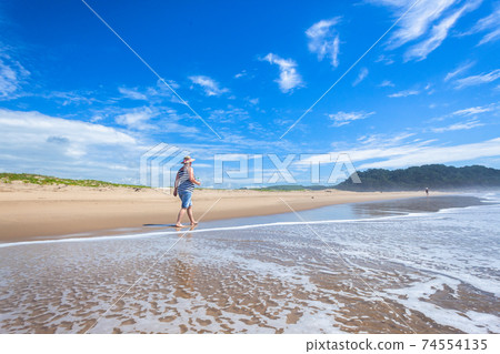 Woman Walking Beach Ocean Waterline Woman Walking Beach Ocean Waterline 74554135