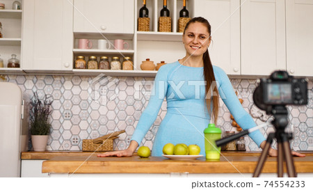 Satisfied healthy young girl recording her video blog episode about healthy food 74554233