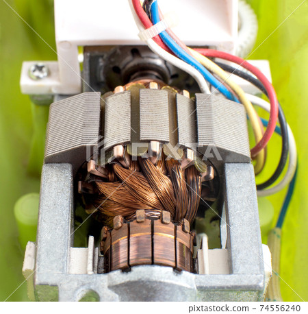 Broken electric motor in a household appliance hand mixer. Malfunction of the rotor and stator of electrical components, close-up Broken electric motor in a household appliance hand mixer. Malfunction of the rotor and stator of electrical components, close-up 74556240