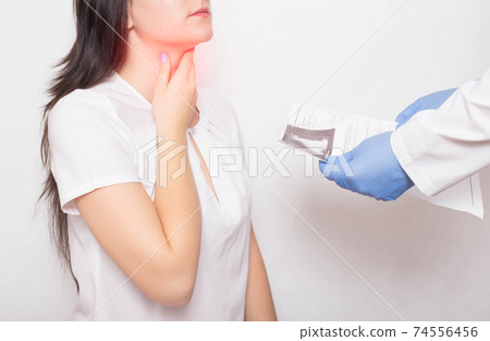 The doctor holds the results of examination of the girl's throat in his hands. Concept of symptoms and sore throat in coronavirus. Reinfection COVID-19, pain 74556456