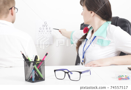A female doctor, an ophthalmologist, checks the patient s kachets and visual acuity with glasses. Selection of eye glasses and lensmetry, background A female doctor, an ophthalmologist, checks the patient s kachets and visual acuity with glasses. Selection of eye glasses and lensmetry, background 74557517