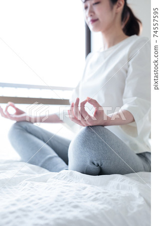 Young woman meditating at home Young woman meditating at home 74557595
