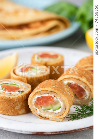Crepe salmon rolls with cream cheese and cucumber Crepe salmon rolls with cream cheese and cucumber 74559550