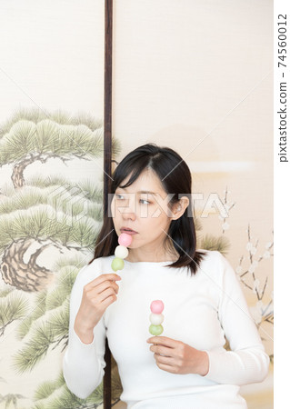 一個女人坐在日式房間裡吃餃子 74560012