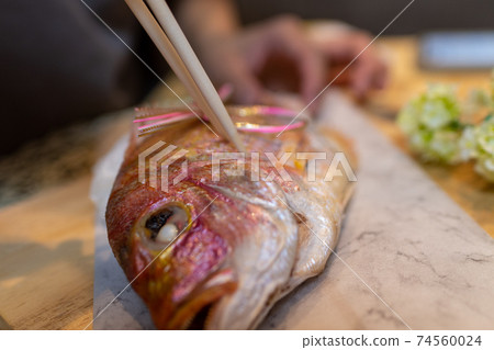 Put chopsticks in salt-grilled sea bream Eat sea bream 74560024