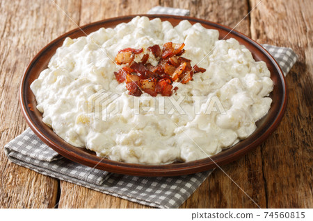 Slovak national dish Bryndzove halusky is made of small potato dumplings and a creamy cheese sauce closeup on the table. horizontal 74560815