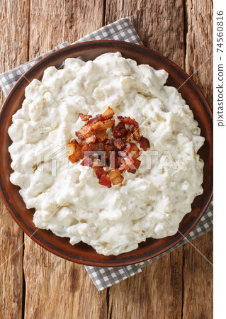 Bryndzove Halusky Slovakian Potato Dumplings with Bryndza Cheese closeup in the plate. Vertical top view 74560816