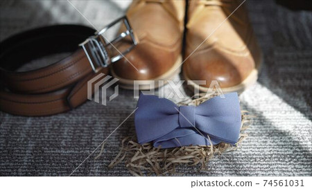 Fees the groom. The morning of the groom. Boots, butterfly, belt Wedding details. Male casual outfits. Top view, flat lay Fees the groom. The morning of the groom. Boots, butterfly, belt Wedding details. Male casual outfits. Top view, flat lay 74561031