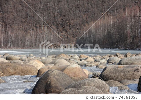A river in Yakutia with large stones. The river in Yakutia, against the background of the forest. A river in the north in summer. A river in Yakutia with large stones. The river in Yakutia, against the background of the forest. A river in the north in summer. 74561055
