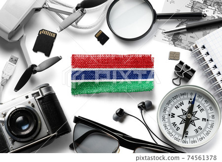 Flag of Gambia and travel accessories on a white background. 74561378
