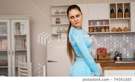 Beautiful woman in sports uniform is preparing for sports training at home Beautiful woman in sports uniform is preparing for sports training at home 74561885