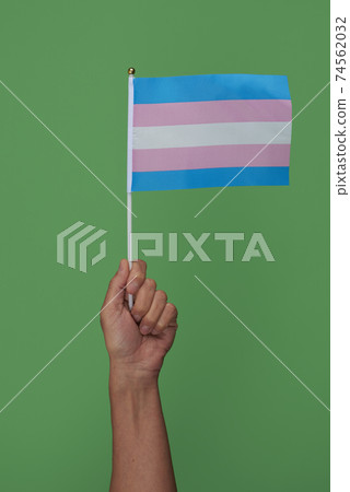 person with a transgender pride flag in the hand 74562032