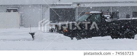 Private contractor plowing parking lot during a blizzard Private contractor plowing parking lot during a blizzard 74563723