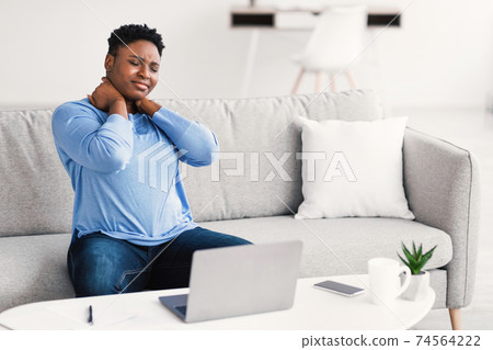 Portrait of black woman with neck pain after work Portrait of black woman with neck pain after work 74564222