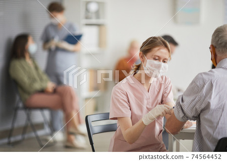 Female Nurse Vaccinating Senior Man Female Nurse Vaccinating Senior Man 74564452