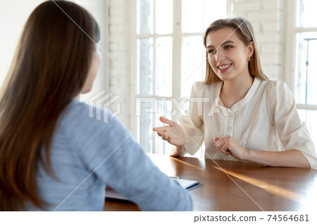 Happy millennial female job seeker making self-presentation to employer. Happy millennial female job seeker making self-presentation to employer. 74564681