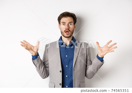 Shocked bearded guy in jacket spread hands sideways, gasping and looking concerned, standing against pink background wearing suit Shocked bearded guy in jacket spread hands sideways, gasping and looking concerned, standing against pink background wearing suit 74565351