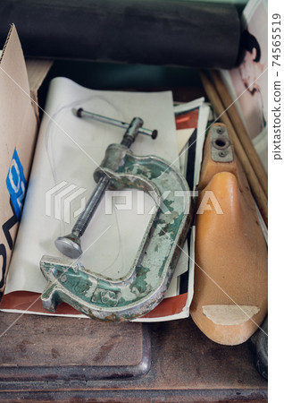 In the shoe workshop, insoles, boot blanks, fasteners, and drawings are placed on a wooden table 74565519