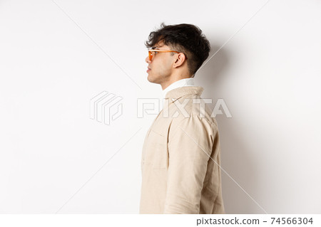 Profile of handsome caucasian man in eyewear, looking at empty space left with serious face, standing on white background Profile of handsome caucasian man in eyewear, looking at empty space left with serious face, standing on white background 74566304