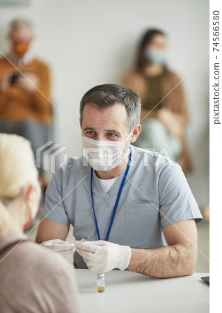 Male Doctor Consulting Patient at Vaccination Male Doctor Consulting Patient at Vaccination 74566580