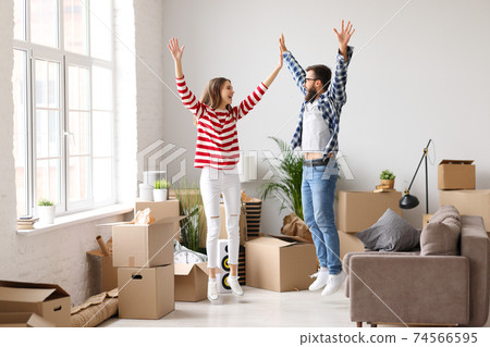 Excited couple celebrating relocation in new apartment 74566595