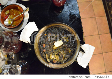 Squid ink paella. Ahijo. sangria. pitcher. glass. floor. tile. Paper napkin. Basque. Squid ink paella. Ahijo. sangria. pitcher. glass. floor. tile. Paper napkin. Basque. 74566613
