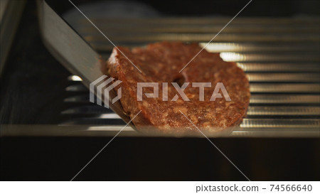 Concept of finishing cooking a black burger Burger with black buns. Sliced vegetables and meat. Taste the best hamburger. Black burger on the table. Cutlets turn over on the grill. Concept of finishing cooking a black burger Burger with black buns. Sliced vegetables and meat. Taste the best hamburger. Black burger on the table. Cutlets turn over on the grill. 74566640