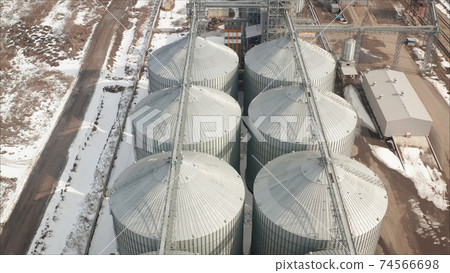 Metal grain elevator in agricultural zone. Industrial elevator Metal grain elevator in agricultural zone. Industrial elevator 74566698