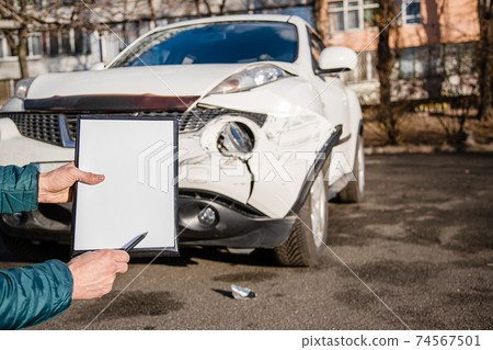 Space for text, blank document close up. An insurance agent will inspect and inspect vehicle damage after an accident. 74567501