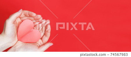 female hands hold a red heart on the palms isolated on a red background. Love, Wedding, Valentines day, 8 March concept. female hands hold a red heart on the palms isolated on a red background. Love, Wedding, Valentines day, 8 March concept. 74567983