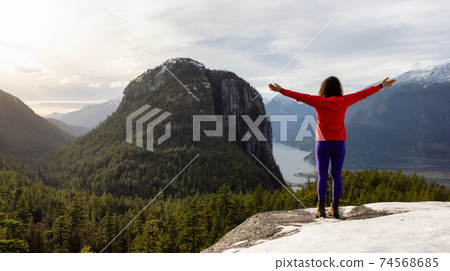 Adventurous Girl Hiking in the mountains during a sunny Autumn Sunset. 74568685