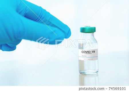 Development and creation of a coronavirus vaccine COVID-19 .Coronavirus Vaccine concept in hand of doctor blue vaccine jar. Vaccine Concept 74569101