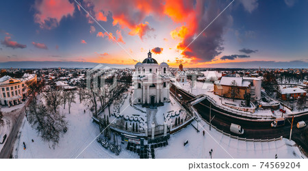 Panoramic aerial view of the cathedral and church in snow-covered small european city at bright winter sunset 74569204