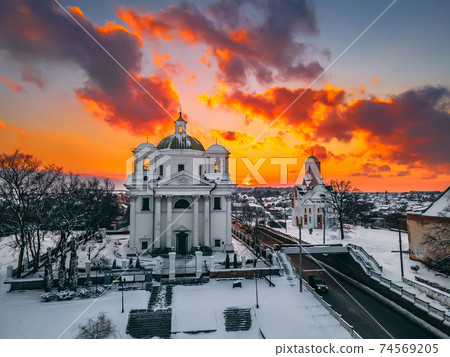 Aerial view of the cathedral and church in snow-covered small european city at bright winter sunset Aerial view of the cathedral and church in snow-covered small european city at bright winter sunset 74569205