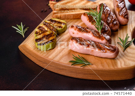 Tasty, fresh sausages grilled with vegetables spices and herbs 74571440