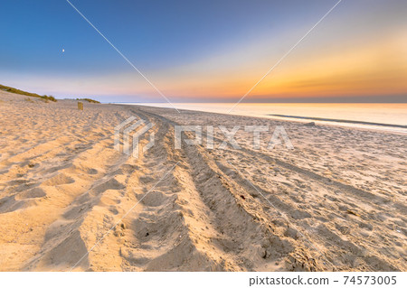 Car tracks Sunset View over ocean from dune in Zeeland Car tracks Sunset View over ocean from dune in Zeeland 74573005