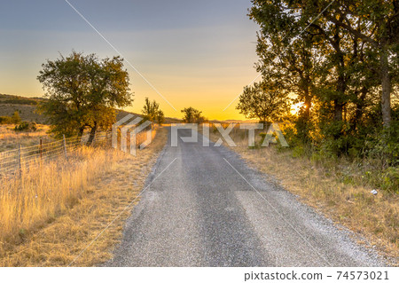 Sunrise over road in Causse Blandas 74573021
