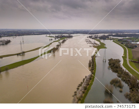 Flooded river landscape in winter Flooded river landscape in winter 74573175