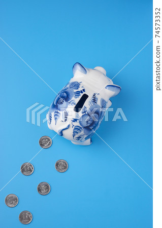 Piggy bank left traces of coins on a blue 74573352