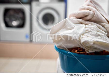 Laundry, House work, Chores concept. close-up photo of basin with dirty clothes to be washed in washing machine Laundry, House work, Chores concept. close-up photo of basin with dirty clothes to be washed in washing machine 74573526