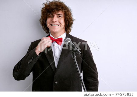 smiling male speaker stand fixing a tie before performance smiling male speaker stand fixing a tie before performance 74573935
